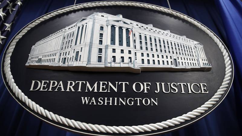 FILE - In this Thursday, April 18, 2019 file photo, a sign for the Department of Justice hangs...