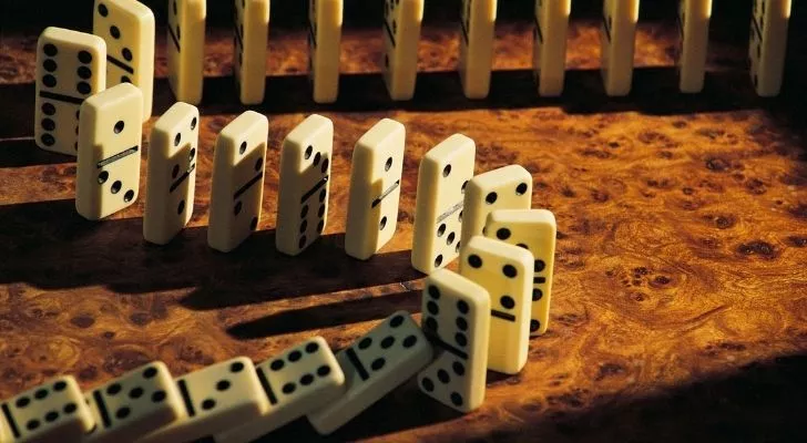 Stacked dominos tumbling over